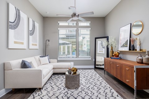 a living room with a white couch and a ceiling fan